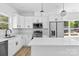 The kitchen features white cabinets, stainless steel appliances, and an island with breakfast bar at 1615 Carlton Ave, Kannapolis, NC 28083