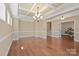 Formal dining room with tray ceiling, hardwood floors, and elegant chandelier lighting at 224 Alexandria Dr, Mooresville, NC 28115