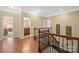 Hallway with hardwood floors featuring a dark wooden banister with views of a bathroom and bedroom at 224 Alexandria Dr, Mooresville, NC 28115