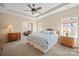 Spacious primary bedroom featuring a ceiling fan, neutral walls, large bed and a sitting area at 224 Alexandria Dr, Mooresville, NC 28115