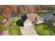 Aerial view showcasing a charming home with a manicured lawn, a fire pit, and lake access at 226 Hermance Ln, Mooresville, NC 28117