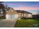 Charming home featuring a well-manicured lawn, attached two-car garage, and stone accents at 226 Hermance Ln, Mooresville, NC 28117