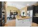 Stylish kitchen island with granite countertop, dark cabinetry, and stainless steel appliances overlooking the dining area at 226 Hermance Ln, Mooresville, NC 28117