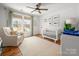 Bright Bedroom with a rocking chair, crib, and a window overlooking the front yard at 230 Pond View Ln, Fort Mill, SC 29715