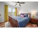 Bedroom with a bed, two windows with yellow curtains, ceiling fan, and side tables with lamps at 230 Pond View Ln, Fort Mill, SC 29715
