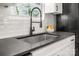 Kitchen with black counter, backsplash, and faucet, with view from window at 230 Pond View Ln, Fort Mill, SC 29715
