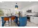 Bright open kitchen offers white cabinets, stainless appliances, island with seating and stylish pendant light at 230 Pond View Ln, Fort Mill, SC 29715