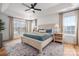 Bright bedroom with large bed, hardwood floors, natural light, and ceiling fan at 230 Pond View Ln, Fort Mill, SC 29715