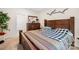 Cozy bedroom featuring a wooden bed frame and dresser, with neutral walls and a decorative wall hanging at 3222 Maple Ridge Dr, Gastonia, NC 28052