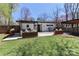 Full backyard view with custom outdoor bar, wood planters, patio, and lawn at 324 East End S Ave, Statesville, NC 28677