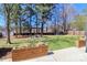 Spacious backyard with lush lawn, mature trees, and a pergola-covered seating area, perfect for outdoor enjoyment at 324 East End S Ave, Statesville, NC 28677