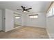 Bright bedroom featuring a mirrored closet, ceiling fan, window, and neutral carpet at 324 East End S Ave, Statesville, NC 28677