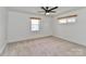 Bright bedroom features a ceiling fan, two windows, carpeted floors, and neutral paint at 324 East End S Ave, Statesville, NC 28677