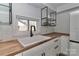 Bright kitchen with a deep farmhouse sink, butcher block counters and open shelving at 324 East End S Ave, Statesville, NC 28677