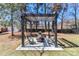 Backyard pergola with seating, fire pit, and wooded views; great for relaxation at 324 East End S Ave, Statesville, NC 28677