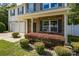 Charming front porch with a seating area, lush bushes, and well-maintained landscaping enhances curb appeal at 352 Nantucket Way, Rock Hill, SC 29732