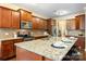 Spacious kitchen with a large island, granite countertops, stainless steel appliances, and dark wood cabinets offers ample space at 352 Nantucket Way, Rock Hill, SC 29732