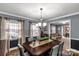 Traditional dining room with gray walls, wood table, chandelier, and view into the living room at 363 Arrowood Ave, Lancaster, SC 29720