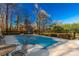 An in-ground pool with cover is situated in a fenced backyard, near outdoor seating and established trees at 363 Arrowood Ave, Lancaster, SC 29720