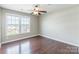 An empty bedroom has wood flooring and a ceiling fan, bathed in natural light at 3960 Town Center Rd, Harrisburg, NC 28075