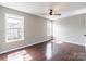A bright, empty bedroom with wood floors has windows and a ceiling fan at 3960 Town Center Rd, Harrisburg, NC 28075