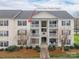 Inviting condo with private balconies, landscaped grounds, and a charming walkway to the entrance at 3960 Town Center Rd, Harrisburg, NC 28075