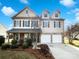 Charming two-story home with a two-car garage and manicured landscaping under a bright blue sky at 5006 Brodie Ln, Fort Mill, SC 29707