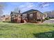 Back exterior showcasing a brick home with a screened-in porch, deck, and a side-entry garage at 5405 Berrywood Ln, Monroe, NC 28110