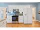 This kitchen features stainless steel appliances, white cabinetry, and wood floors, offering a blend of style and function at 5405 Berrywood Ln, Monroe, NC 28110