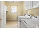 Well-lit laundry room with bright cabinets and new washer and dryer at 5405 Berrywood Ln, Monroe, NC 28110