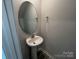 Charming powder room features a pedestal sink with oval mirror at 586 N Sparkleberry St, Chester, SC 29706