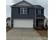 Two-story home featuring a two-car garage, blue siding, and decorative stone accents at 586 N Sparkleberry St, Chester, SC 29706