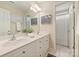 Bright bathroom features a double vanity, tile floors, and a shower with a curtain at 6008 Nuthatch Ct, Charlotte, NC 28277