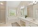 Bright bathroom features a soaking tub, double vanity, tile floors, and shower with glass doors at 6008 Nuthatch Ct, Charlotte, NC 28277