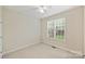 Simple bedroom with neutral walls, carpet, a ceiling fan, and a bright window with natural light at 6008 Nuthatch Ct, Charlotte, NC 28277