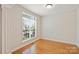 Cozy bedroom with hardwood floors and a large window providing natural light at 6008 Nuthatch Ct, Charlotte, NC 28277