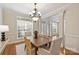 Open dining room with hardwood floors, modern chandelier, large windows and white trim at 6008 Nuthatch Ct, Charlotte, NC 28277