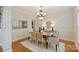 Dining room with wainscoting, modern chandelier, hardwood floors, and neutral decor at 6008 Nuthatch Ct, Charlotte, NC 28277