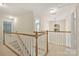 Upstairs hallway with natural light and a view of the staircase, showcasing neutral carpeting and bright walls at 6008 Nuthatch Ct, Charlotte, NC 28277