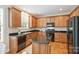 Kitchen features wood cabinets, black appliances, granite counters, and a center island for food preparation at 6008 Nuthatch Ct, Charlotte, NC 28277