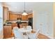 Cozy eat-in kitchen featuring warm wood cabinets, black appliances, granite countertops, and stylish lighting at 6008 Nuthatch Ct, Charlotte, NC 28277