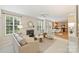 Bright open-concept living room with a fireplace, neutral decor, and a seamless flow into the dining area and kitchen at 6008 Nuthatch Ct, Charlotte, NC 28277