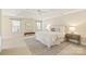 Bright main bedroom with tray ceiling, ceiling fan, ensuite bathroom, and carpeted floors at 6008 Nuthatch Ct, Charlotte, NC 28277