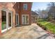 Brick home's backyard features a stone patio, manicured lawn, and screened porch, ideal for outdoor living at 6510 Seton House Ln, Charlotte, NC 28277