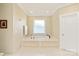 The main bathroom has a white tiled tub with a window for natural light at 6510 Seton House Ln, Charlotte, NC 28277