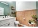 Charming half-bathroom with wood paneling, decorative fixtures, and modern sink and toilet at 693 Luther Dr, Iron Station, NC 28080