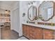 Bathroom with double sink vanity, wooden cabinets, and neutral tile flooring at 704 N Main Ave, Newton, NC 28658