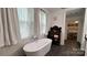 Bright bathroom with a soaking tub, sheer curtains, and stylish wallpaper at 704 N Main Ave, Newton, NC 28658