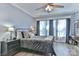 Bedroom features light blue walls, a ceiling fan, a black iron bed, and an abundance of natural light at 704 N Main Ave, Newton, NC 28658