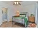 Bedroom featuring a cozy bed with green bedding, complemented by vintage wooden nightstands at 704 N Main Ave, Newton, NC 28658